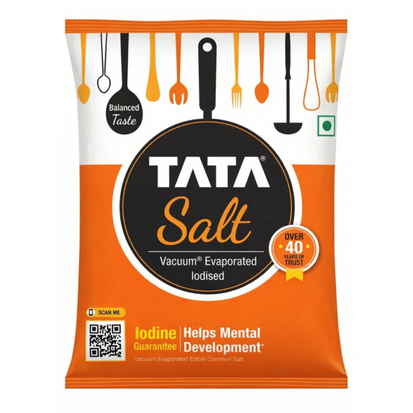 Packet of Tata Iodized Salt standing next to bulk food supplies at Jalaram Food Products warehouse in Ahmedabad.