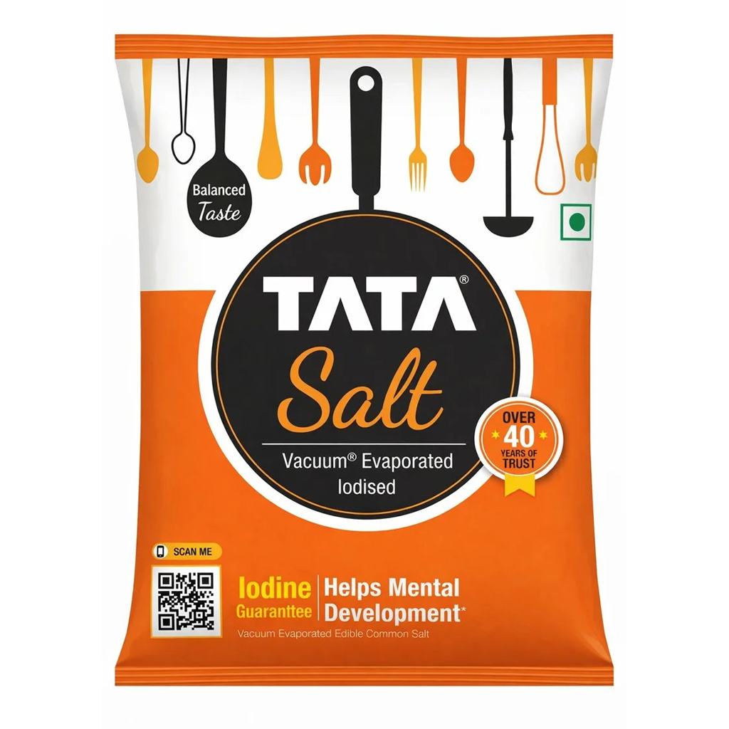 Packet of Tata Iodized Salt standing next to bulk food supplies at Jalaram Food Products warehouse in Ahmedabad.