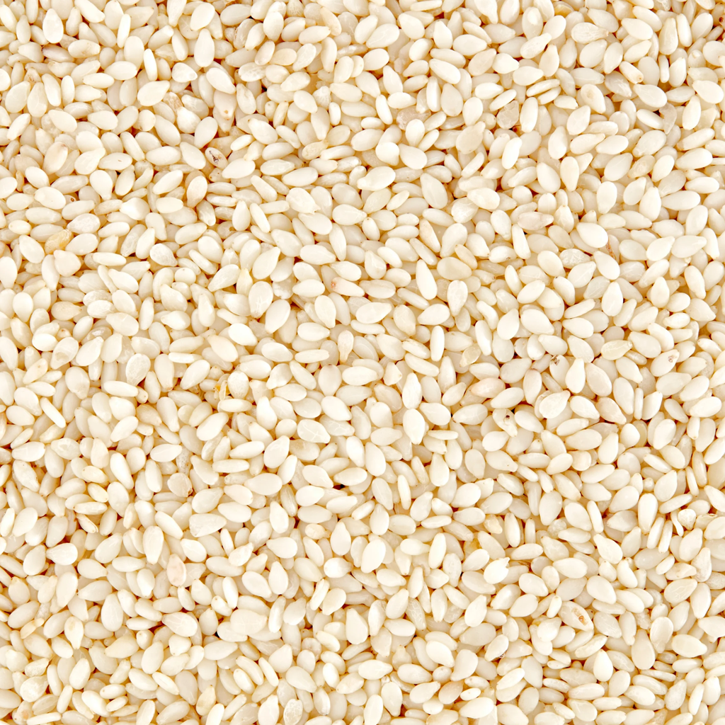 Heap of pristine White Sesame Seeds (Safed Til) next to a bakery bun at Jalaram Food Products.